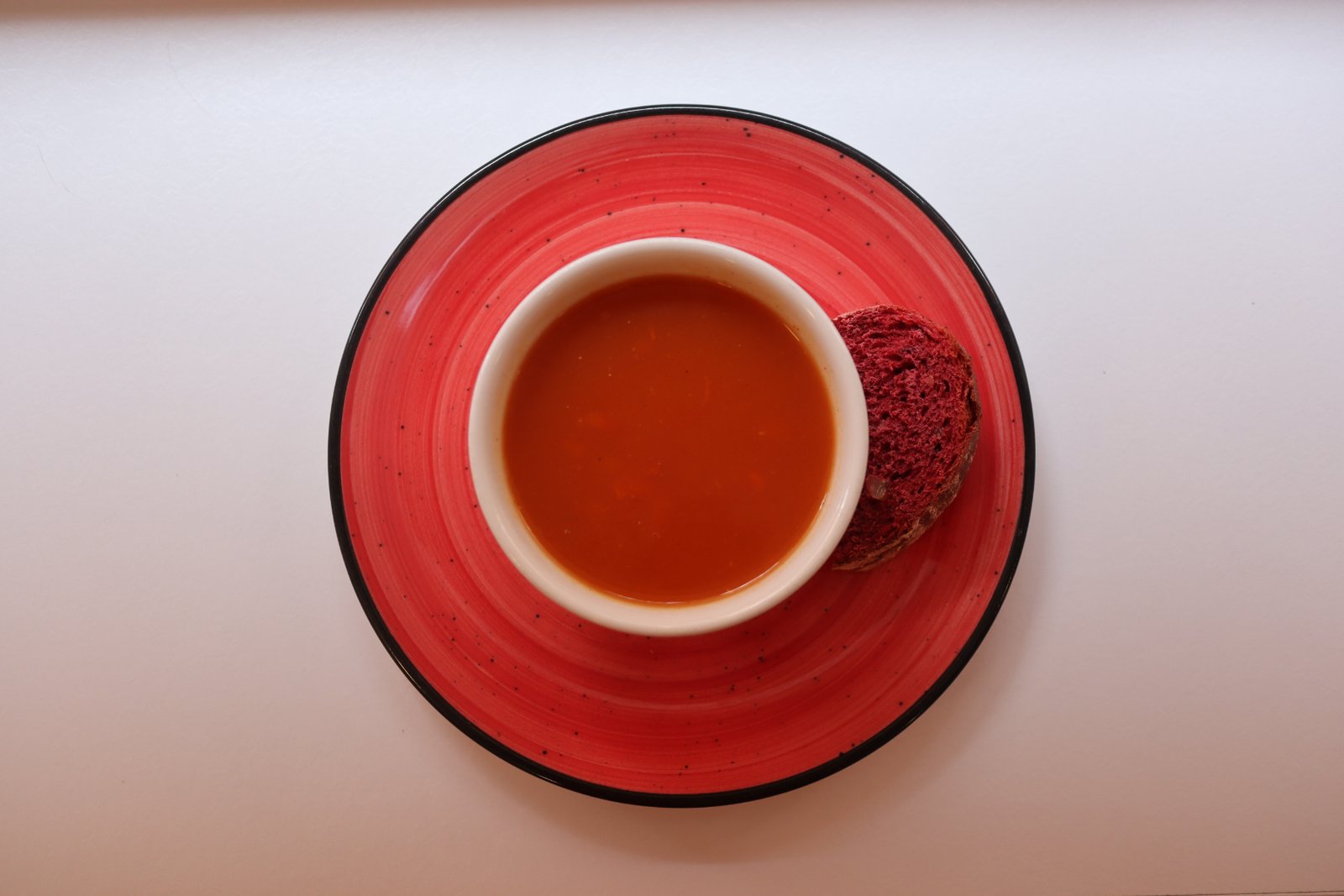 Crema de tomate en plato rojo