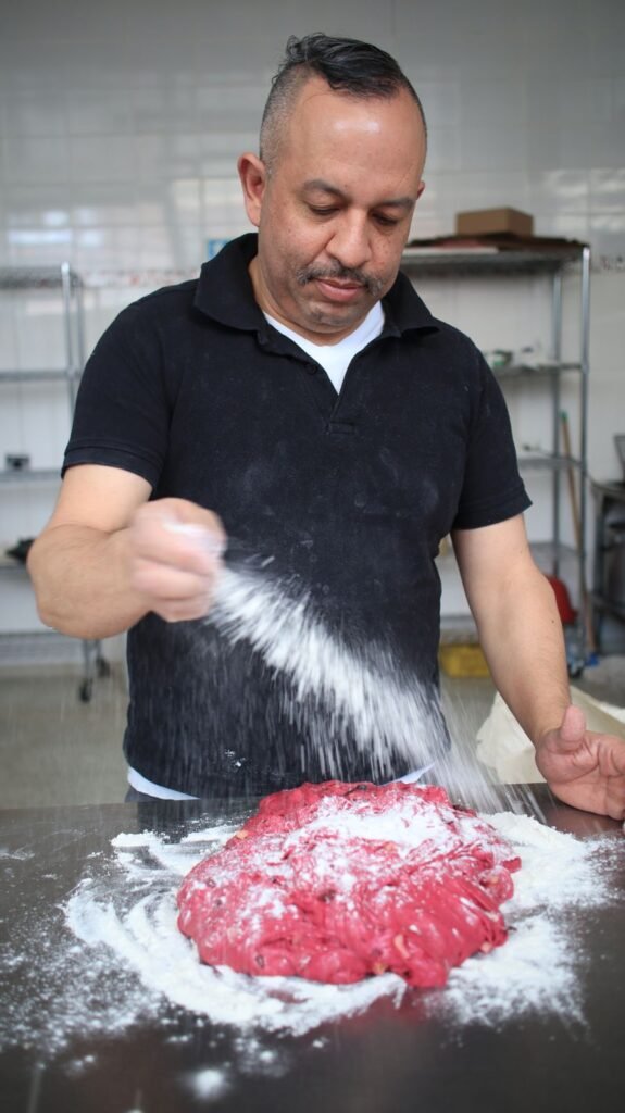 Felipe enharinando una masa de remolacha en la panadería